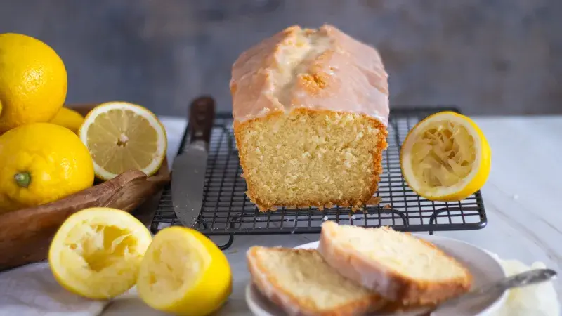 Citronová bábetka s glazurou, řezané kousky a čerstvé citrony.