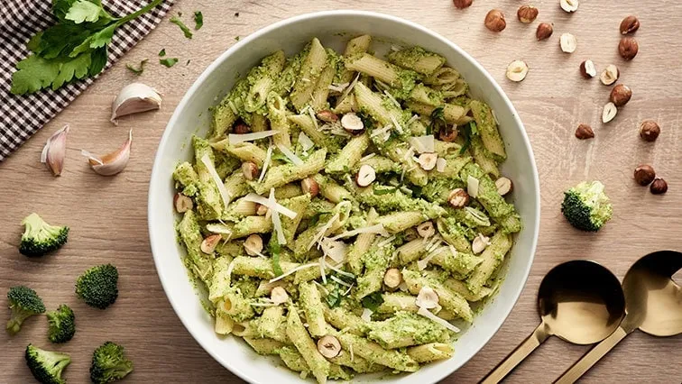 Mísa penne s pesto omáčkou, ořechy, sýr a čerstvé zeleniny.
