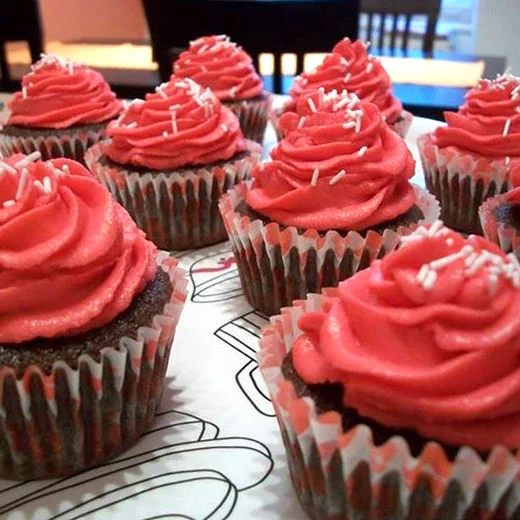Čokoládové muffiny s červenou krémem a stříbrnými posypem.