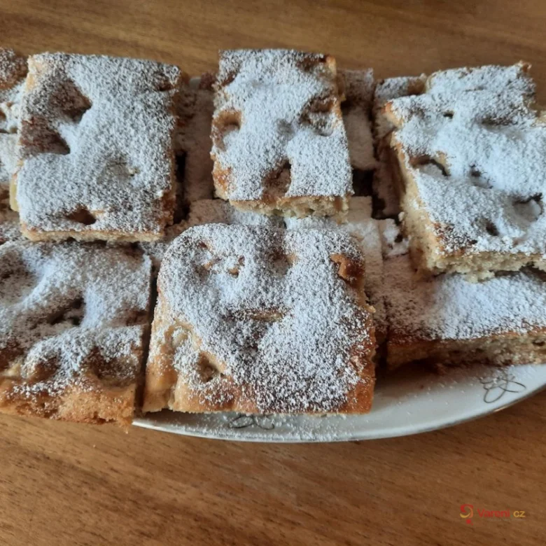 Kusky obráceného jablečného koláče posypané moučkou cukrovou