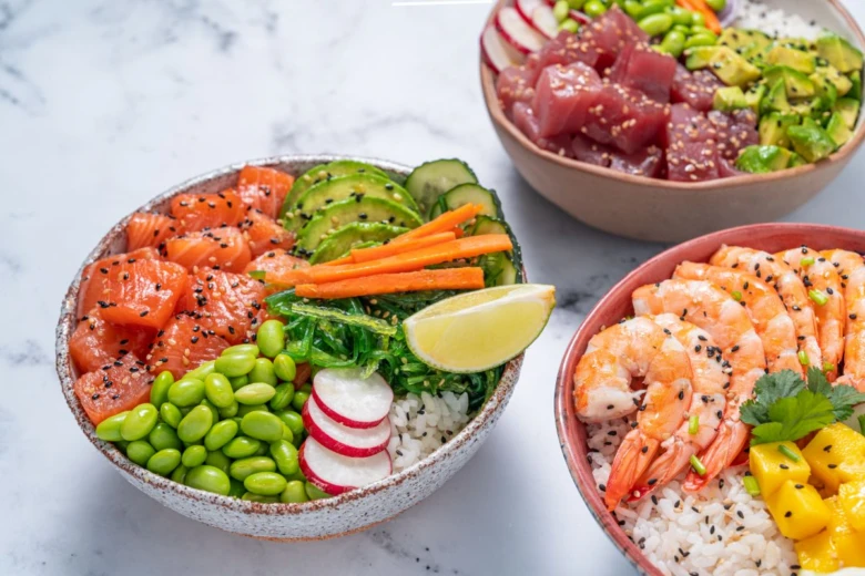 Tři barevné poke bowl s čerstvou rybou, zeleninou, edamame, avokádem, krevetami na rýži