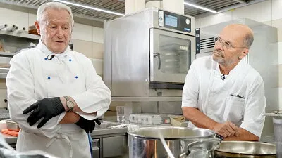 Dva šéfkuchaři v profesionální kuchyni připravují guláš.