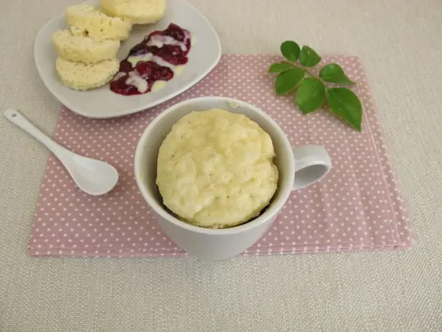 Hot knedlíky v hrnku s džemem na růžovém ubrousku.