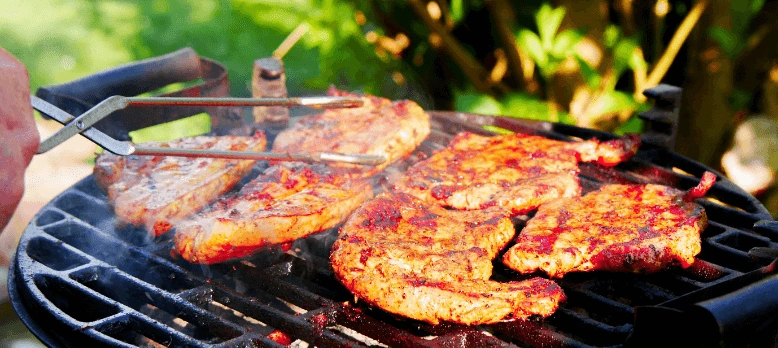 Maso na grilu se smaží venku nad uhlím.