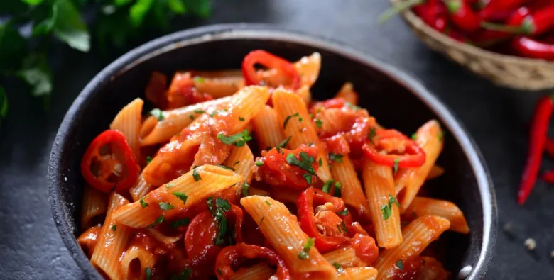 Penne špagety v rajčatové omáčce s čerstvou bylinkou.