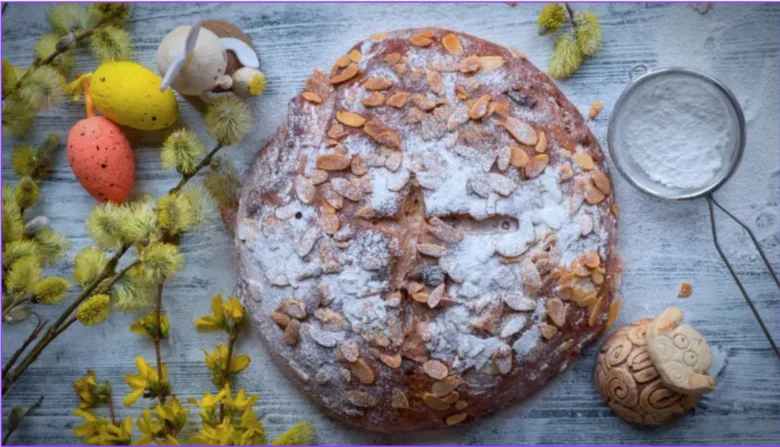 Tradiční easter vdolka posypaná mandlí a moukou s jarními dekoracemi.