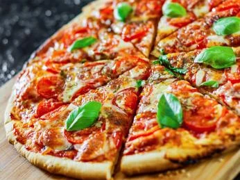 Italská pita s rajčaty a bazalkou na dřevěném podnosu