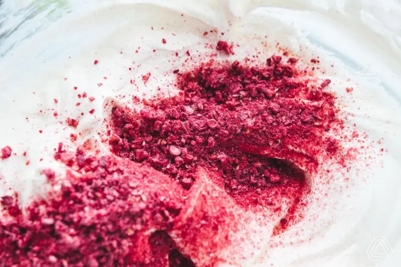 Mleté maliny se přidávají do smetany pro roládu s mascarpone.