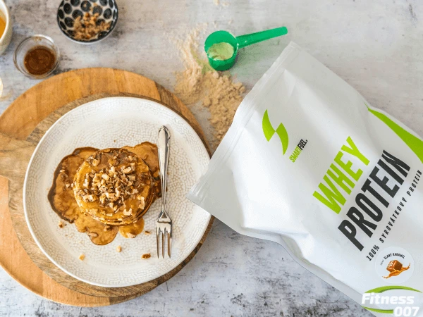 Palačinky s ořechy vedle pytle bílkovin Whey Protein.