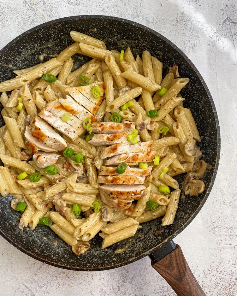 Penne těstoviny se žampiony a kuřecím masem v pánvi.