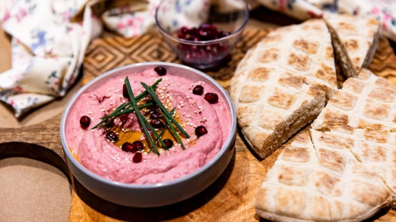 Růžový domácí hummus z cizrny s pita chlebem.