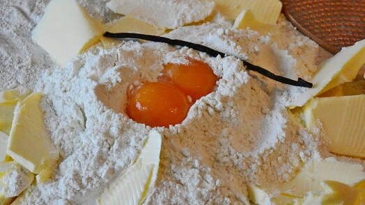 Suroviny na pečení: mouka, vejce a máslo pro bábovkový recept.