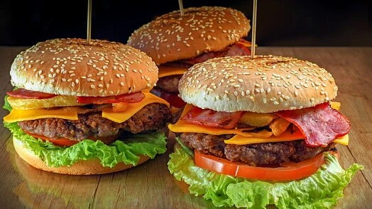 Tři lahodné burgery na hořčicových houskách s čerstvou zeleninou.