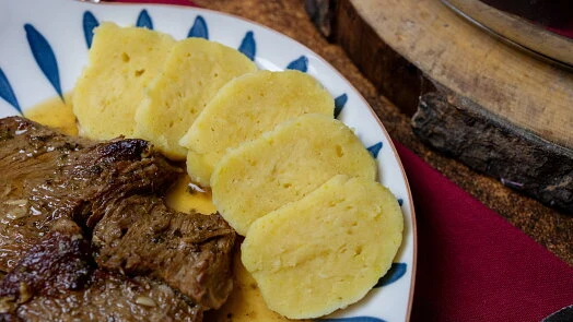 Příprava bramborových knedlíků: hotové plátky s masem.