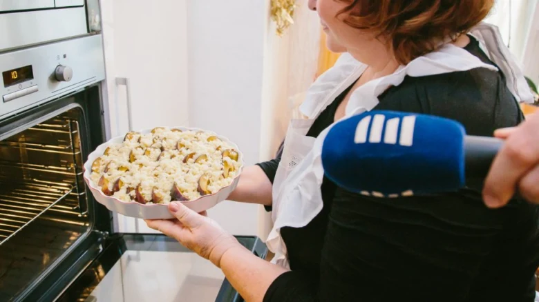 Woman holding plum cake dish