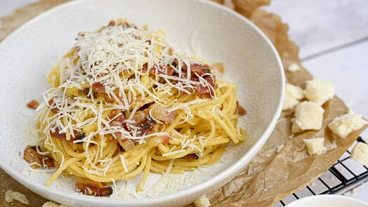 Spaghetti Carbonara s podlívou, šunkou a syrem v misce.