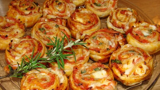 Upečené šneky z listového těsta s pizzou a bylinkami.