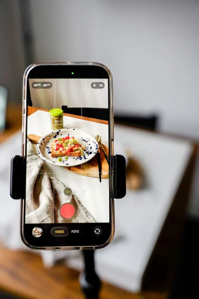 Chytrý telefon fotí zapečené toasty s rajčatovou omáčkou na talíři.