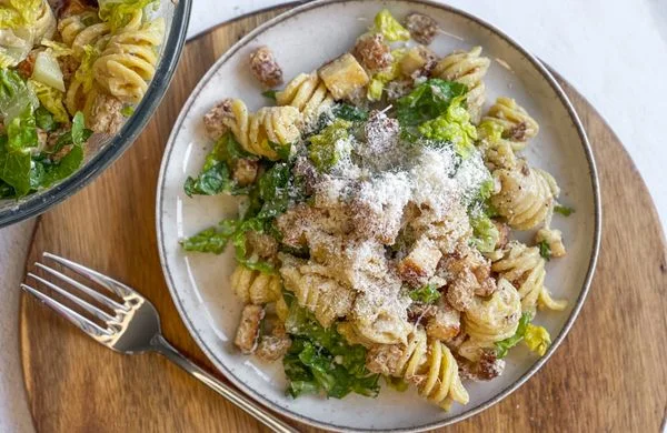 Pasta salát s listovými zeleninovými ingrediencemi na talíři.