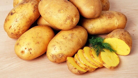 Čerstvé brambory se žlutou kůrou nakrájené na plátky.