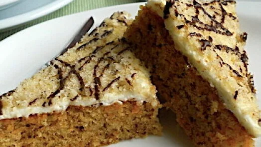 Dvě kousky bábovky s mascarpone na bílém talíři.