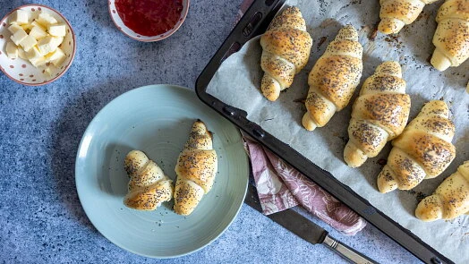 Domácí křupavé rohlíky s semínkem na talíři i plechu.