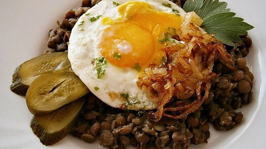 Hot lentil soup served with fried egg, crispy onions and pickled cucumbers.