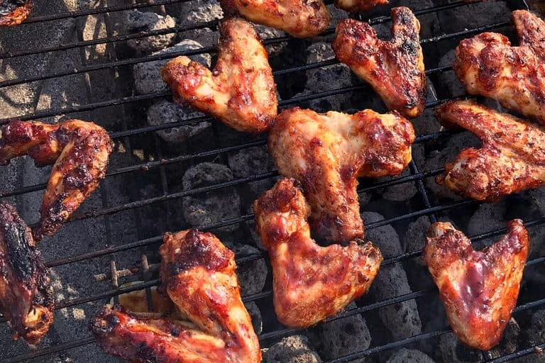 Pečená kuřecí křídla na grilu s omáčkou nad uhlím.