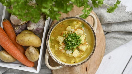 Mísa zeleninové polévky s kapáním, bramborami a celerem.
