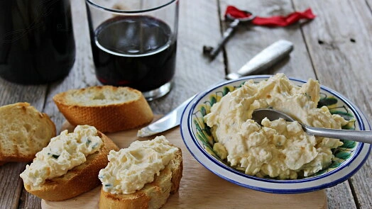 Pomazánka z vajec na toastu s vínem v dřevěném prostoru.