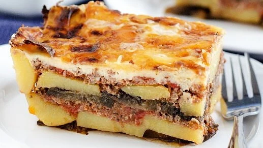 Kousek řecké musaky s masem a lilkem na talíři.